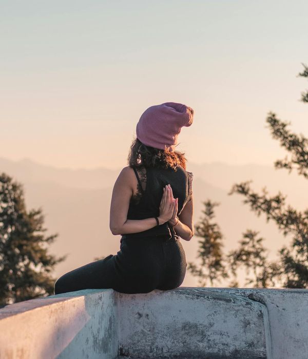 Person viewed from behind, looking out over a calm landscape at sunrise after a practice session.